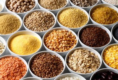 Background of many grains and pulses in white ceramic dishes.